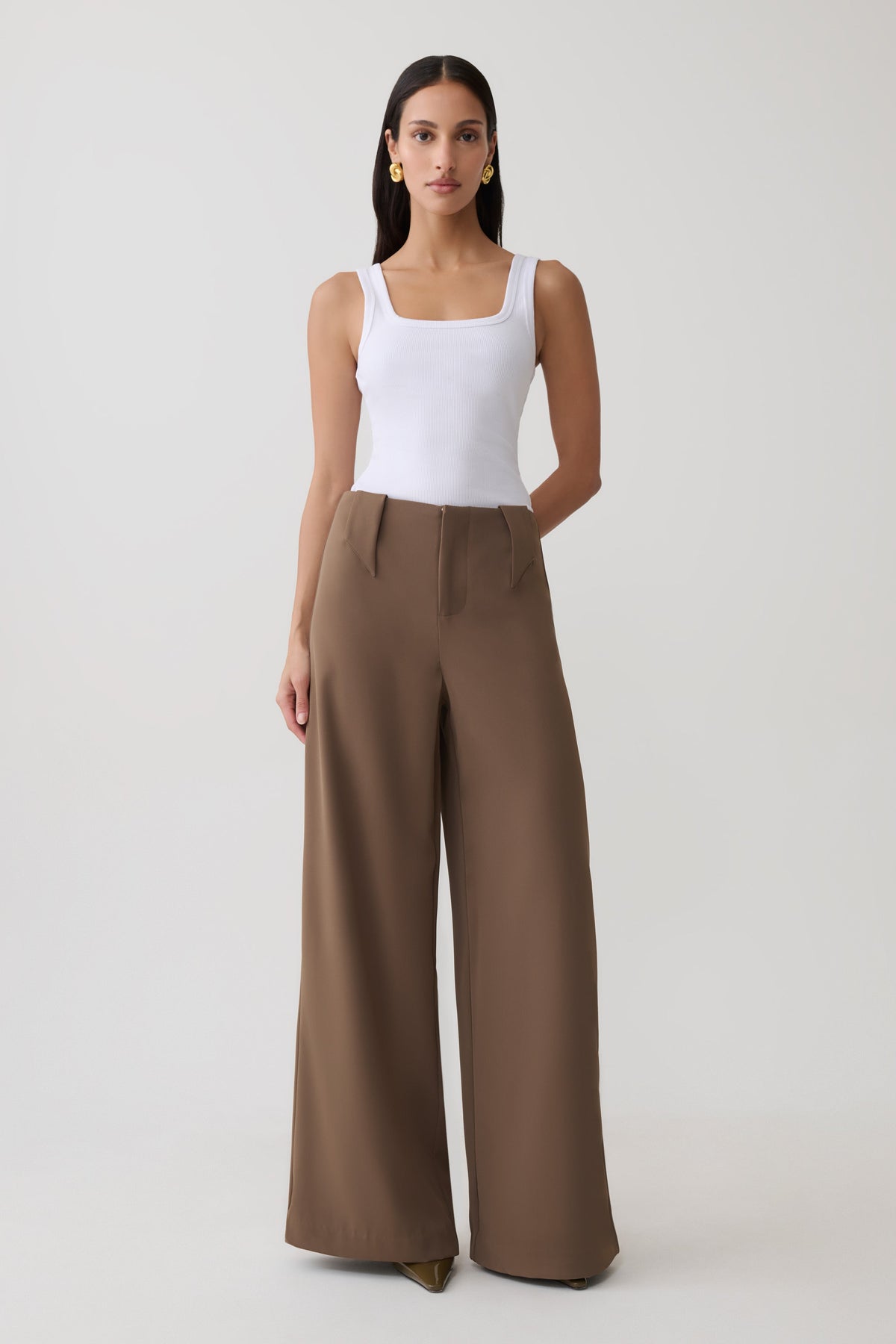 Woman wearing white tank with brown wide leg suiting trouser.