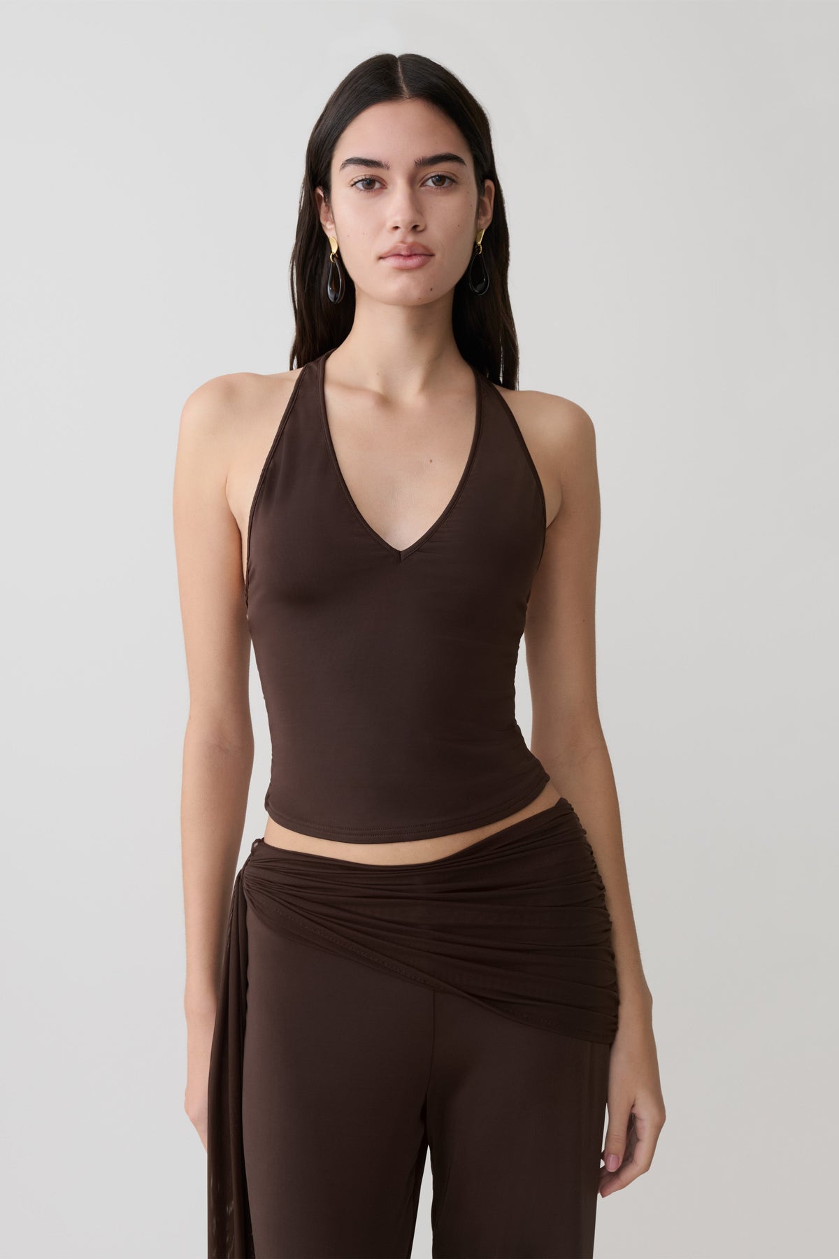 Woman wearing a brown slinky and mesh top.