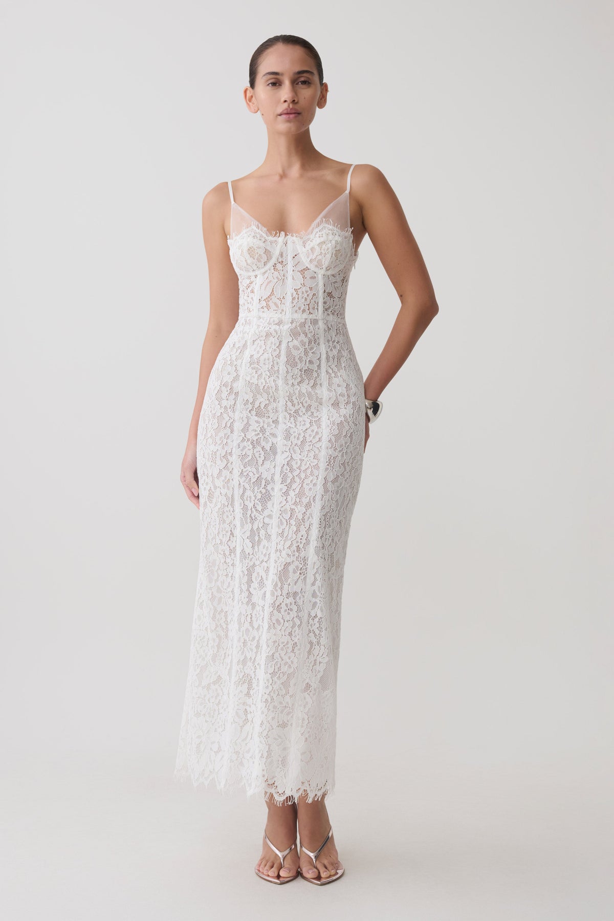 Woman wearing a white lace and mesh midi dress.