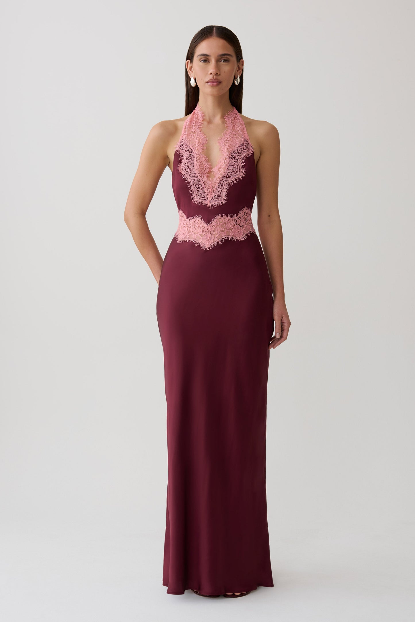 Woman wearing a burgundy satin and lace maxi dress.