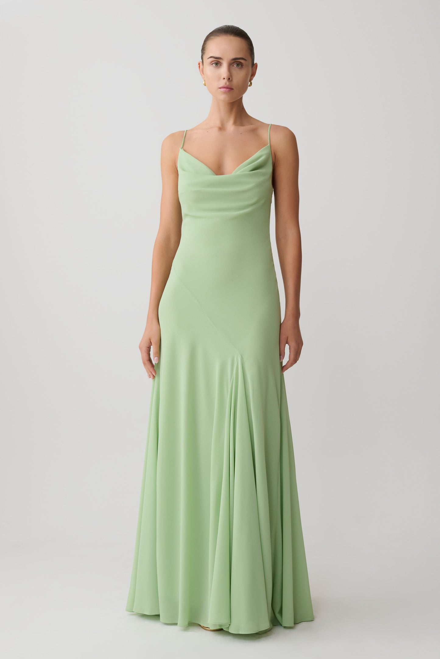 Woman wearing a light green chiffon maxi dress.