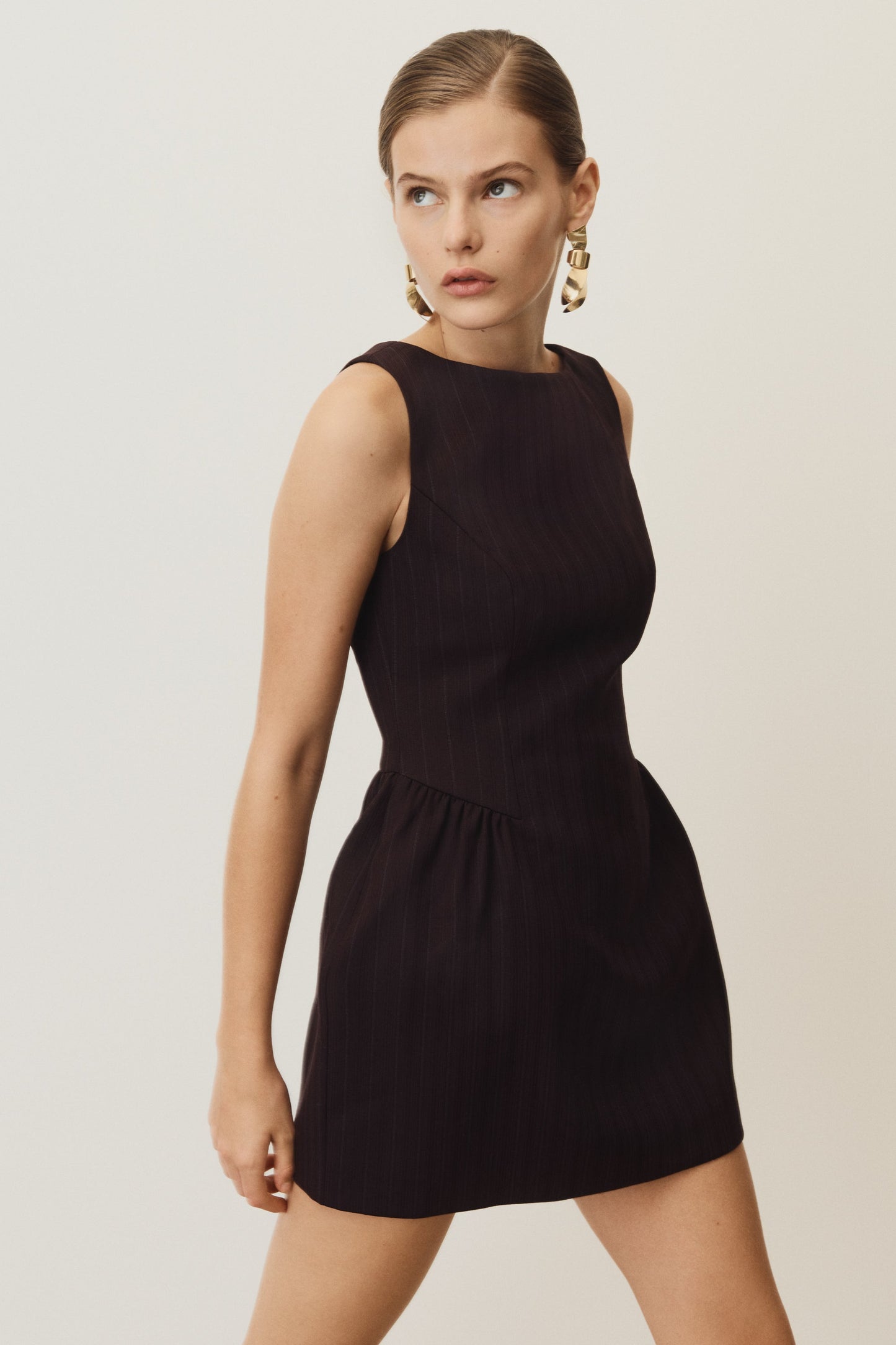 Woman wearing a black dress against a plain background