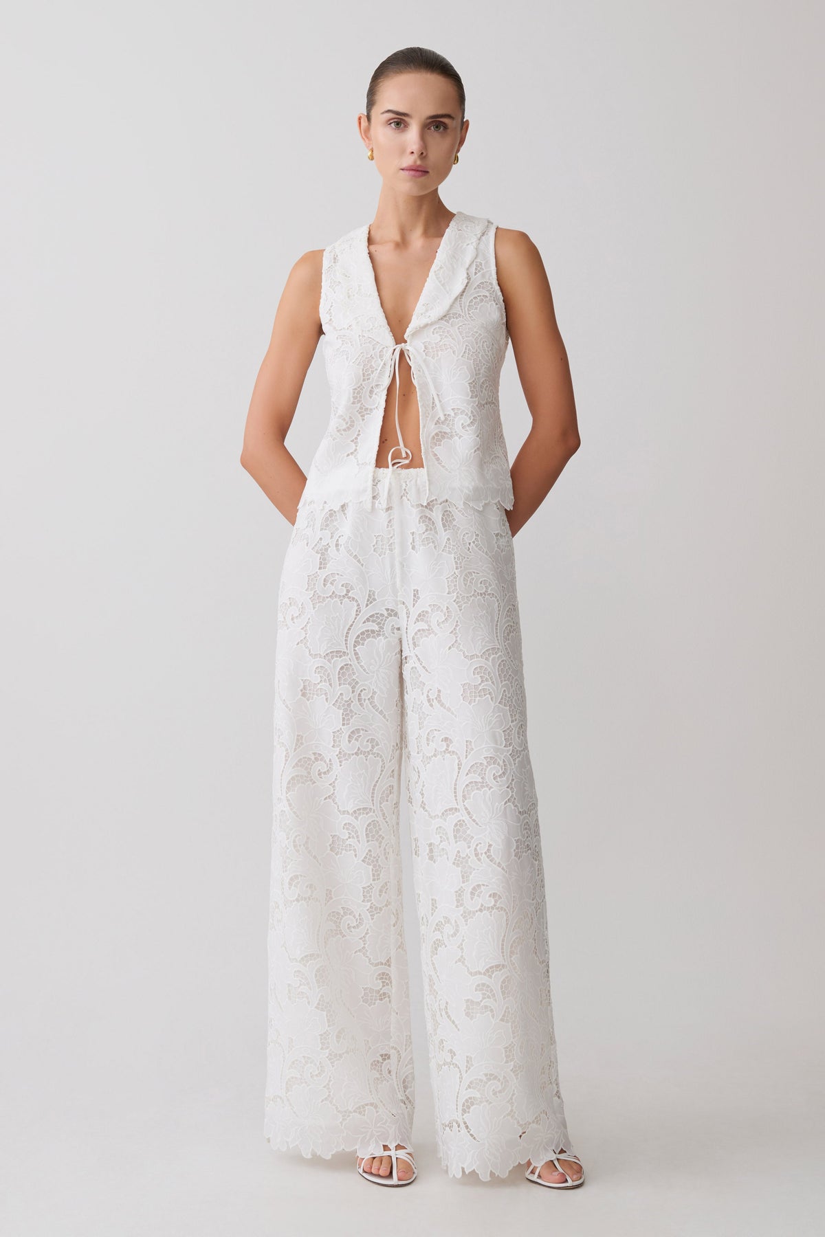 Woman wearing a white broderie tie top with matching pants.