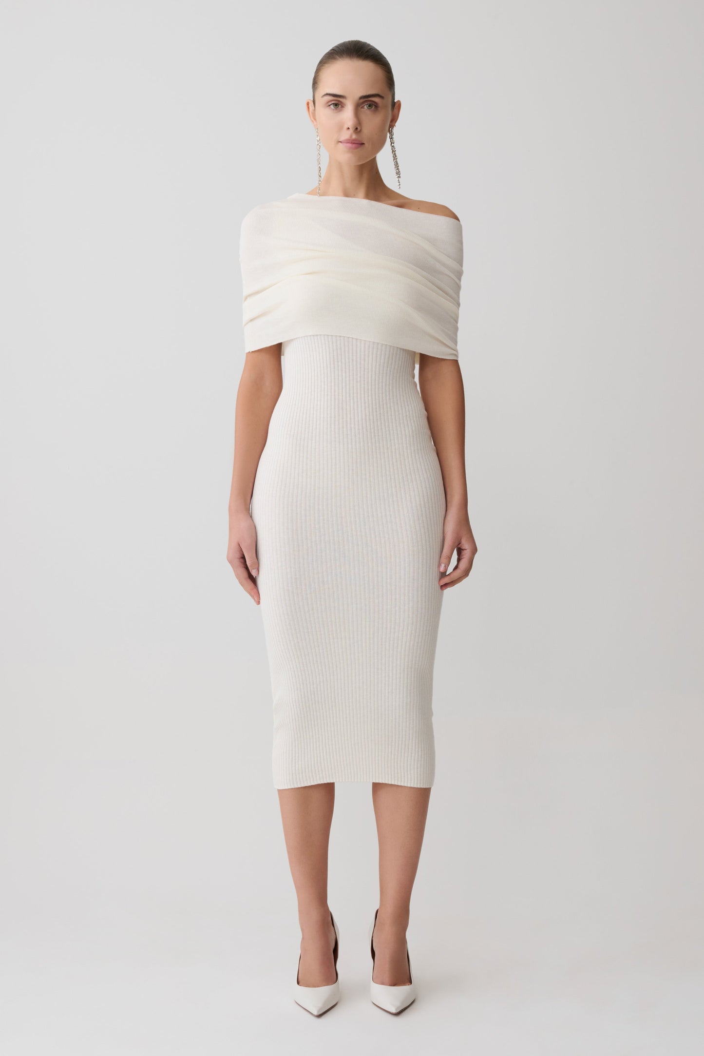 Woman wearing a white off-shoulder dress on a light gray background