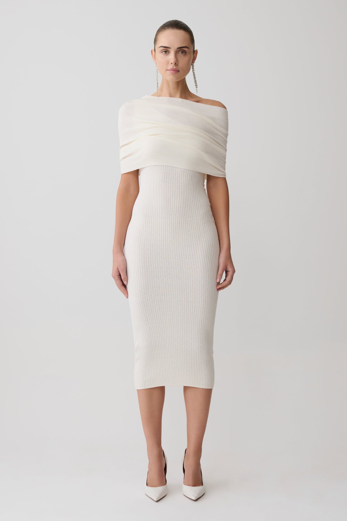 Woman wearing a white off-shoulder dress on a light gray background