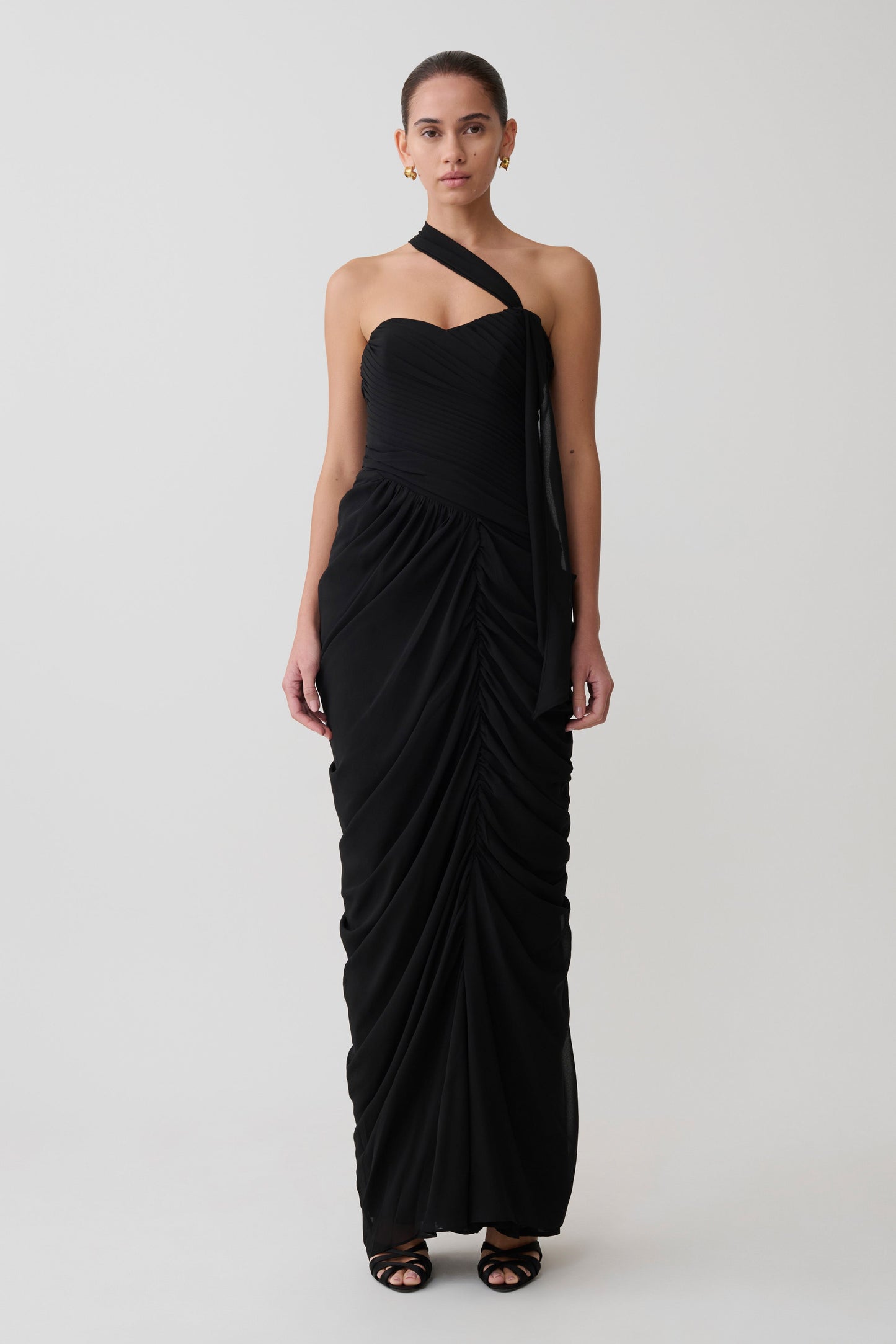 Woman wearing a black one-shoulder dress on a white background