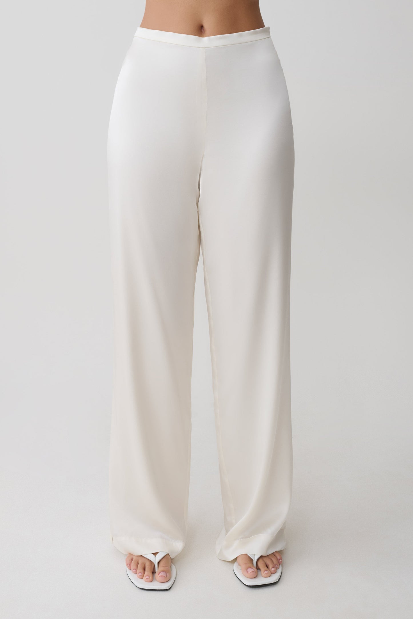 Woman wearing white silk blend pants.
