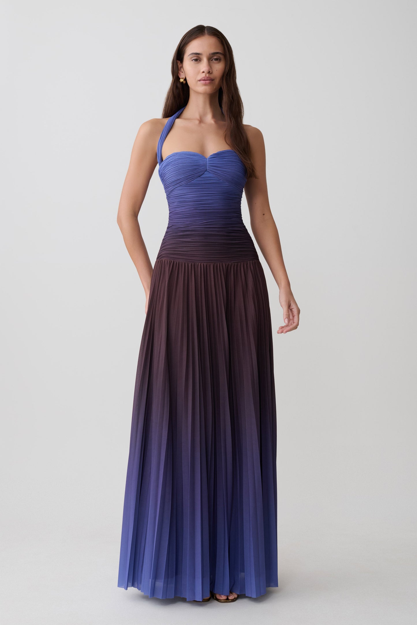 Woman wearing a chocolate and blue ombre pleated halter midi dress.