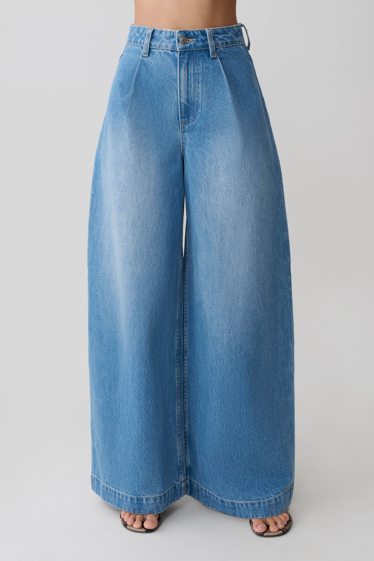 Woman wearing blue oversized jean with front pleat.