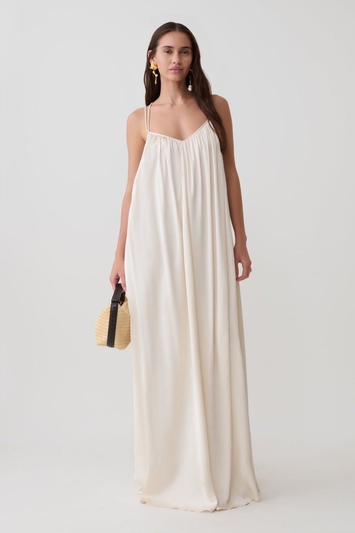 Woman wearing a satin gathered maxi dress.
