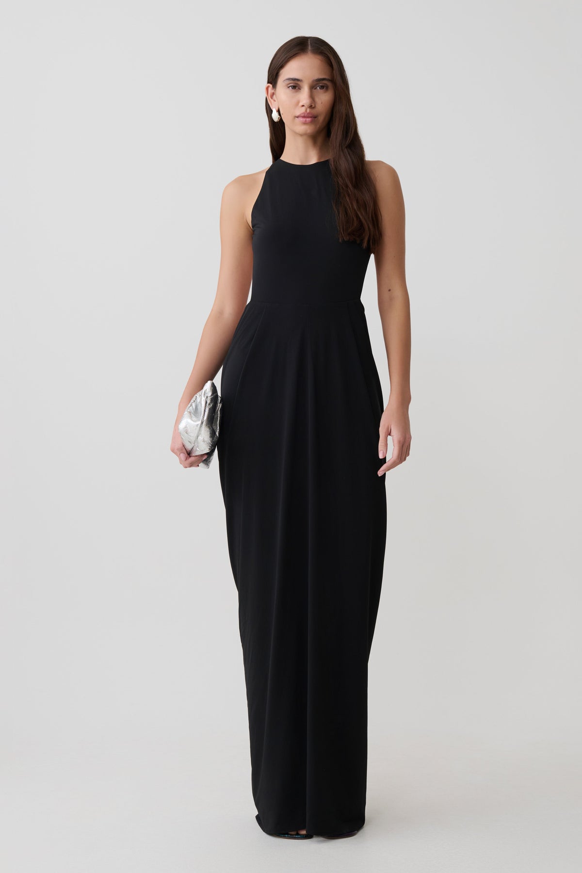 Woman wearing a black low back halter maxi dress.