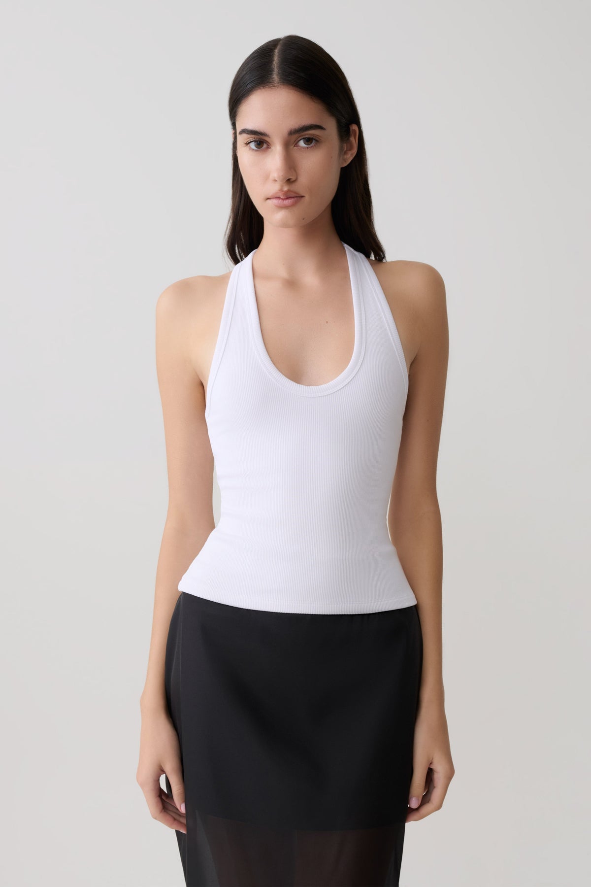 Woman wearing a white ribbed tank.