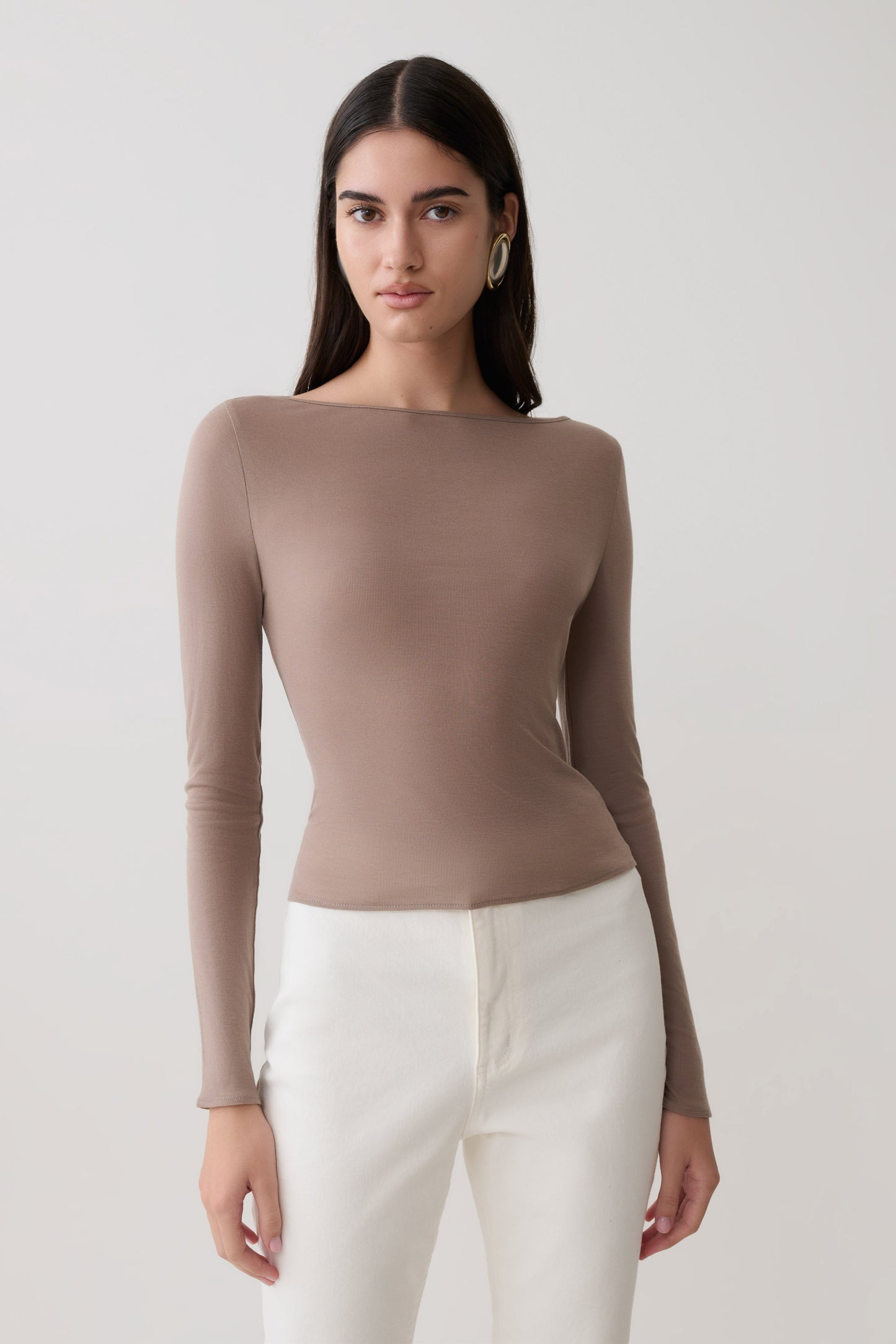 Woman wearing a brown long sleeve sheer top.