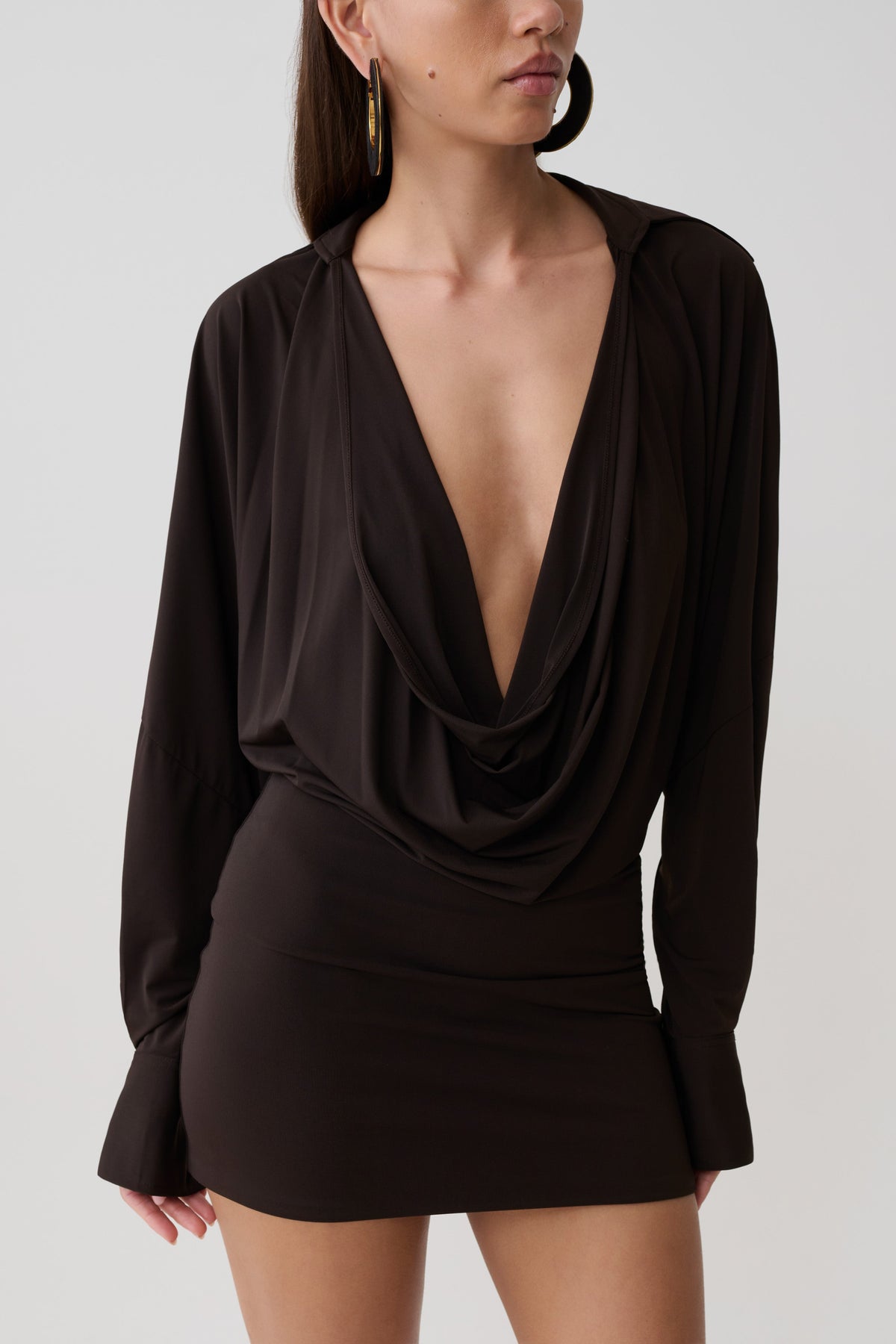 Woman wearing a brown cowl drape shirt dress.