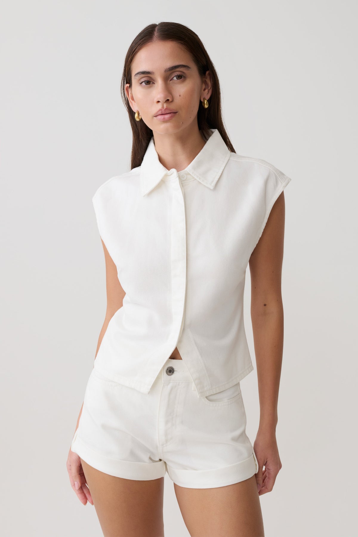 Woman wearing white collared denim longline top with matching denim shorts.