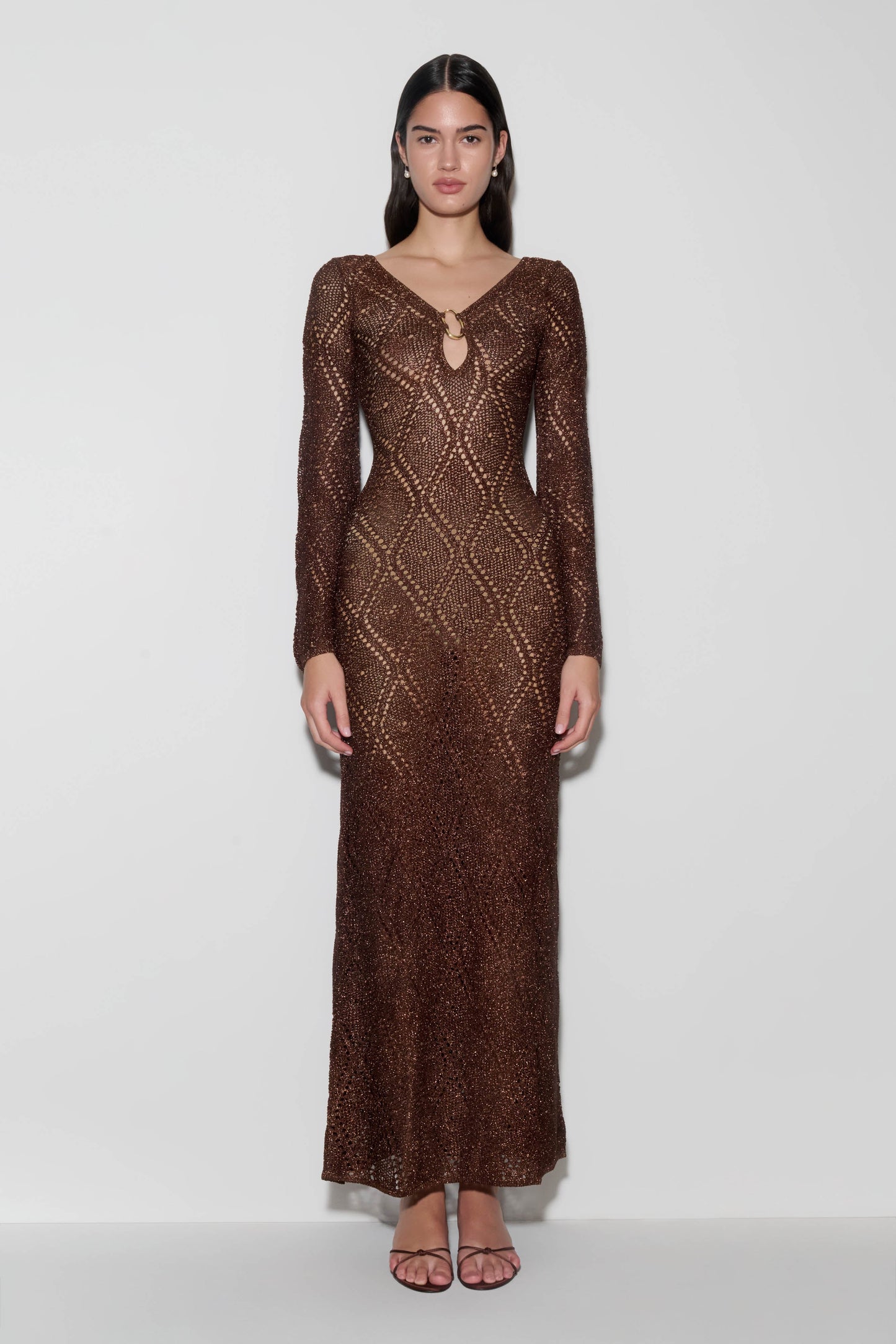 Woman wearing a brown lurex crochet maxi dress.