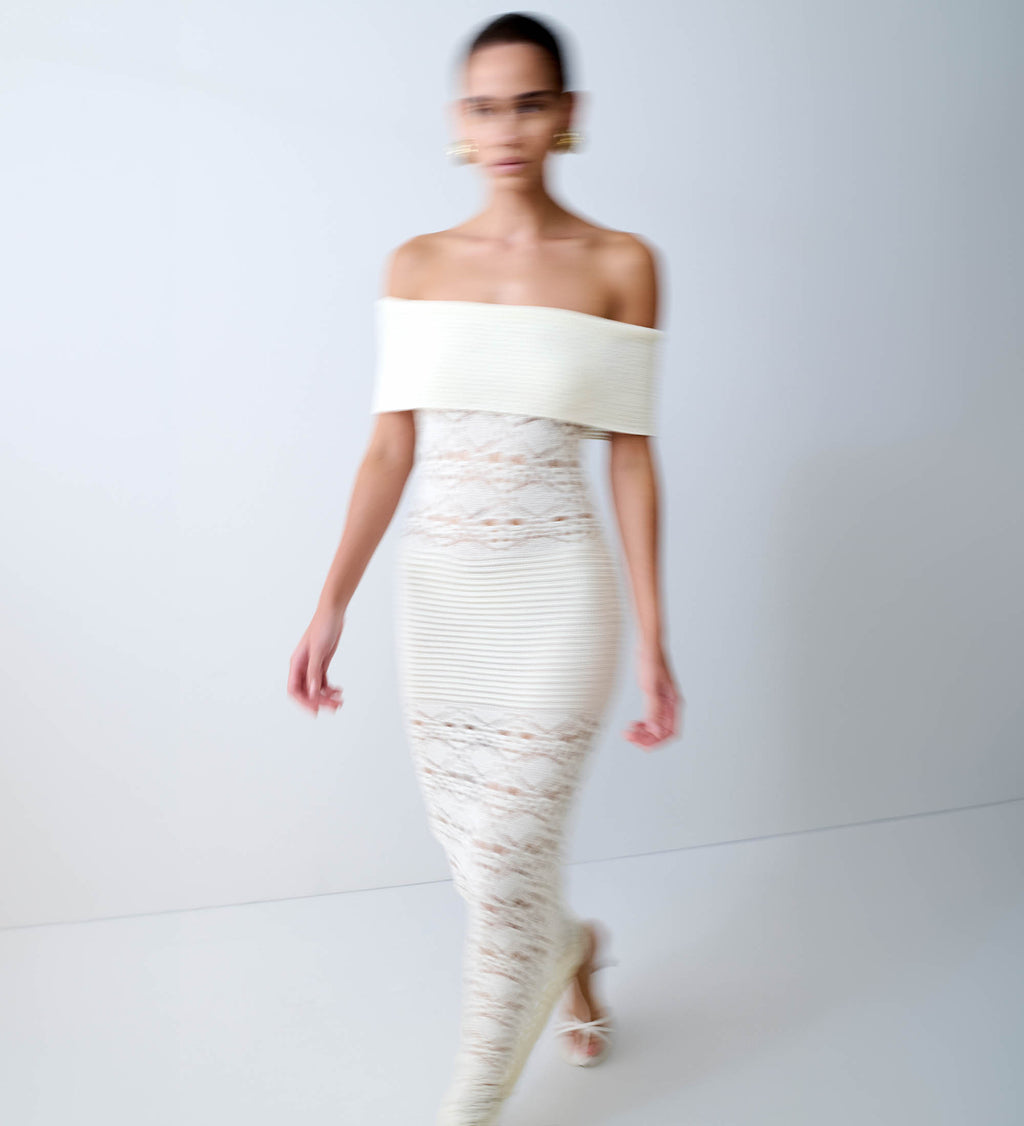 Woman in off shoulder white maxi dress.