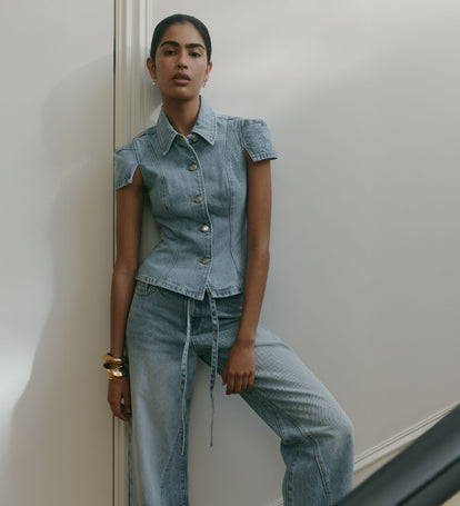 Image of woman wearing denim shortsleeve button up shirt with matching tie up denim jeans