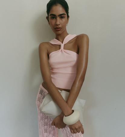 Woman wearing pink halterneck knit top with matching pink crochet pants