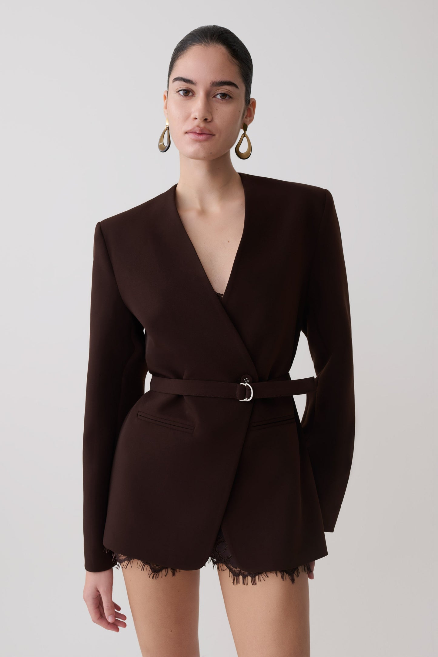 Woman wearing a dark brown drop shoulder suiting blazer.