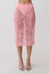 Woman wearing a pink lace midi skirt.