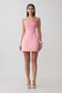 Woman wearing a pink satin corset mini dress.