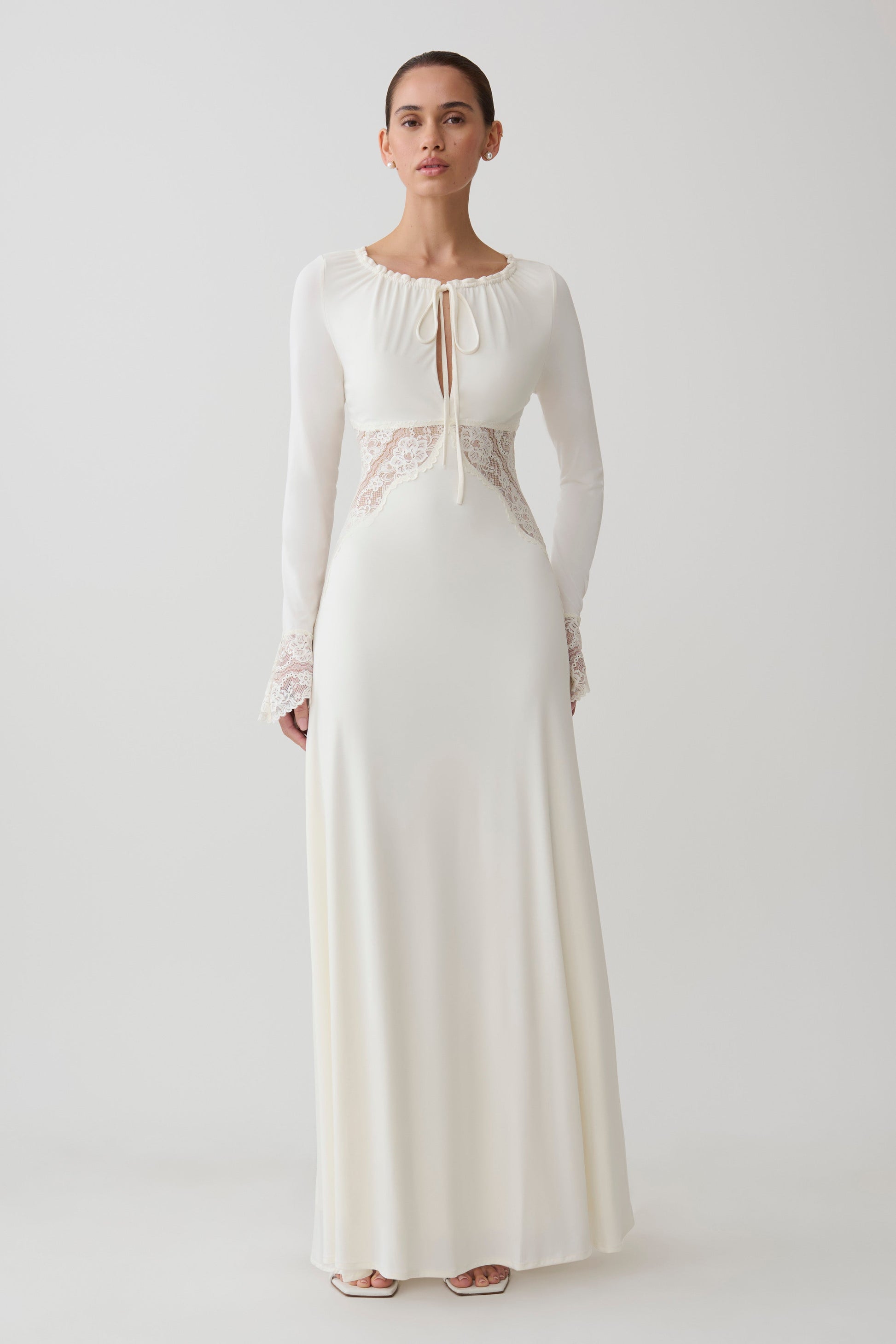 Woman wearing a white lace slinky maxi dress.