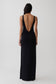 Woman wearing a black backless twist maxi dress.