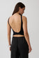 Woman wearing black backless twist top.