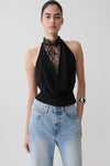 Woman wearing a black chiffon & lace halter top.