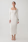 Woman wearing a white long sleeve wool midi dress.