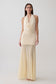 Woman wearing a white draped halter slinky maxi dress.