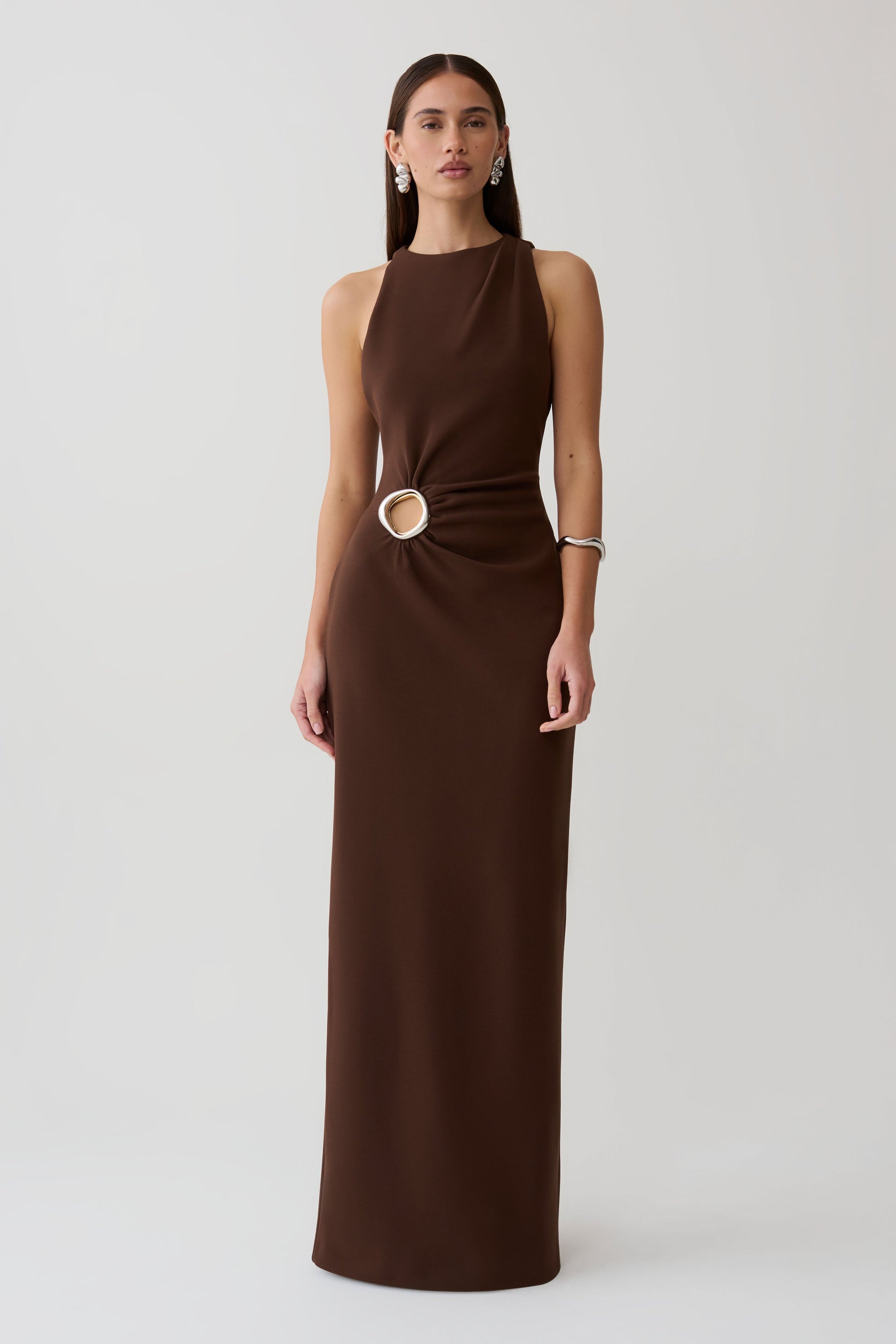 Woman wearing a brown maxi dress with silver hardware.