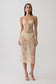 Woman wearing gold lace top with matching midi skirt.