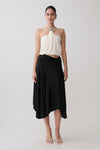 Woman wearing a white halter top and black slinky midi skirt. 