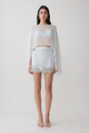 Woman wearing light blue bralette with chiffon cape with matching lace and satin mini skirt.