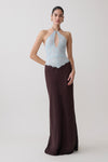 Woman wearing a light blue and dark brown lace and satin halter maxi dress.