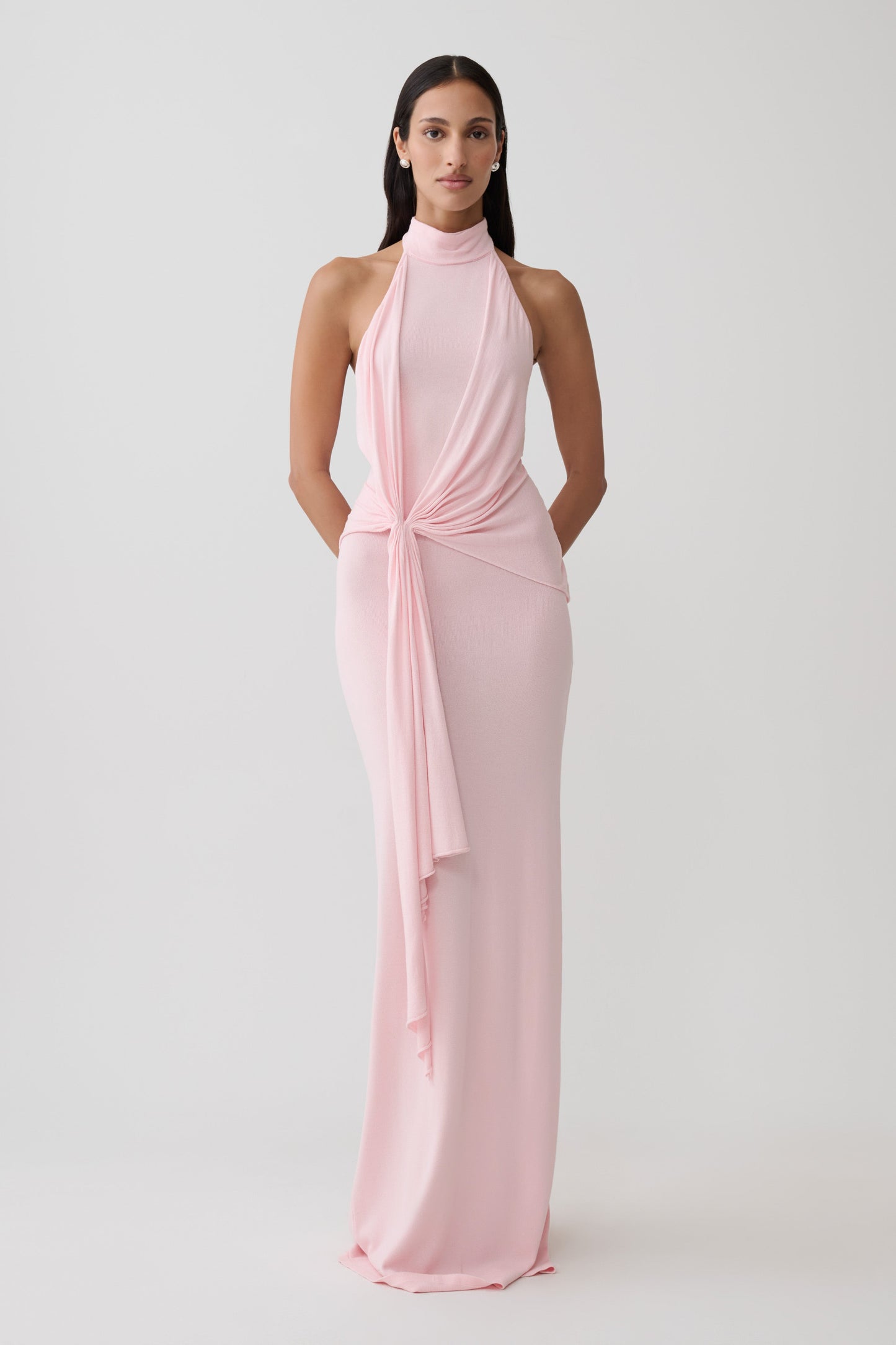 Woman wearing a pink halter knit maxi dress.