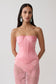 Woman wearing a pink satin strapless corset.