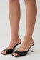 Woman wearing black metal heel sandals.