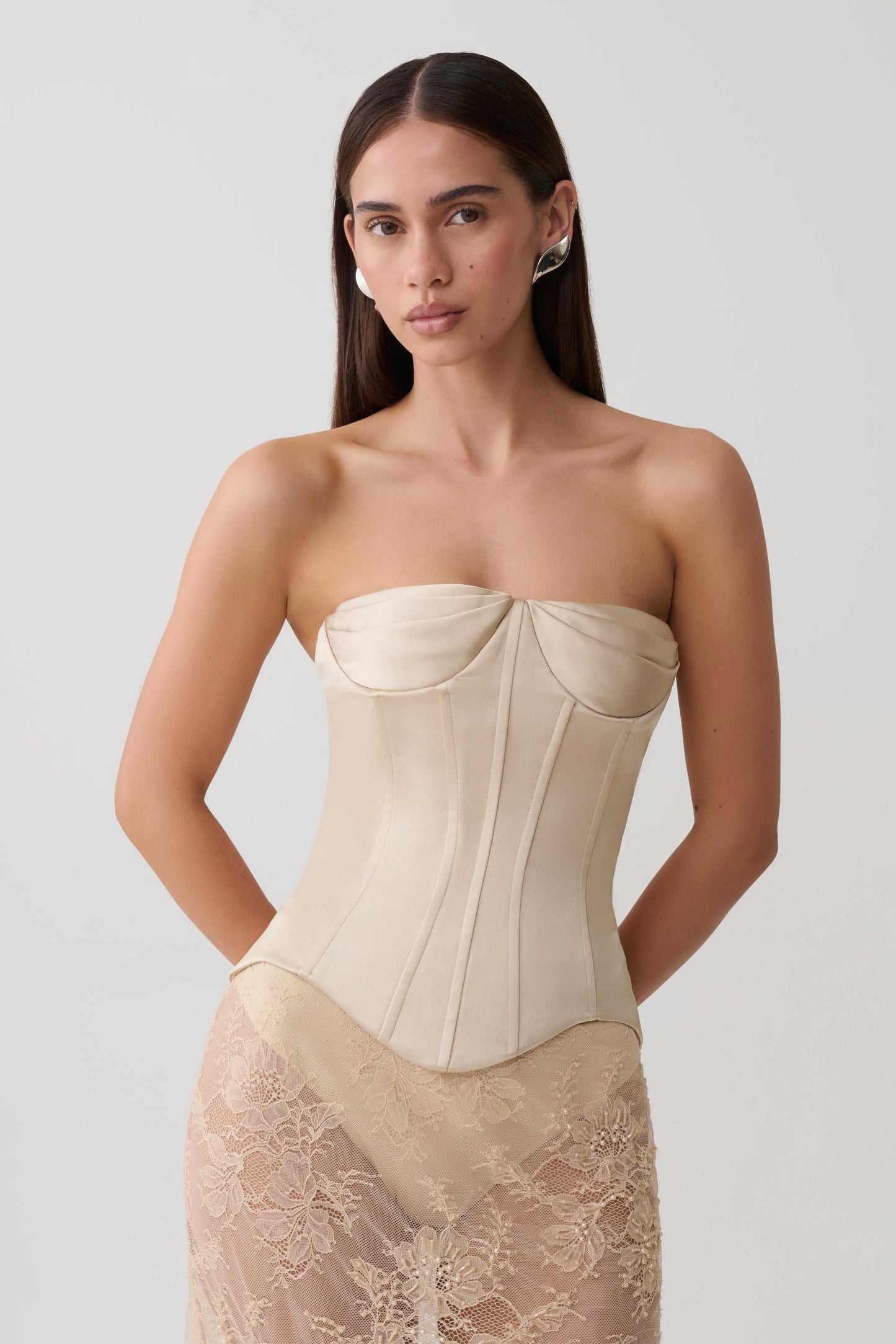 Woman wearing a gold satin strapless corset.