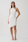 Woman wearing white draped hardware midi dress.