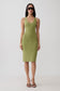 A woman modeling a sleeveless olive green bodycon midi dress with a scoop neckline, paired with dark sunglasses and brown strappy heels, against a plain light gray studio background.