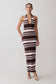 Woman wearing a brown and white striped dress on a plain background
