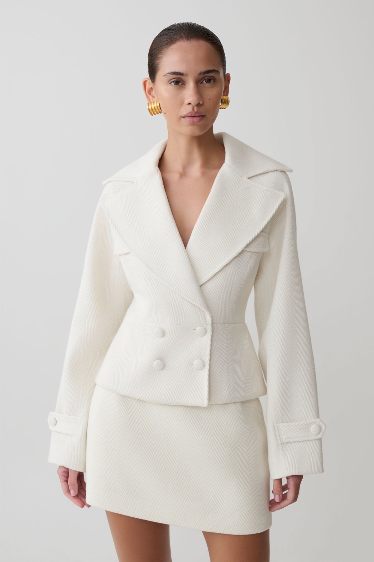 Woman wearing a white suit with a plain background