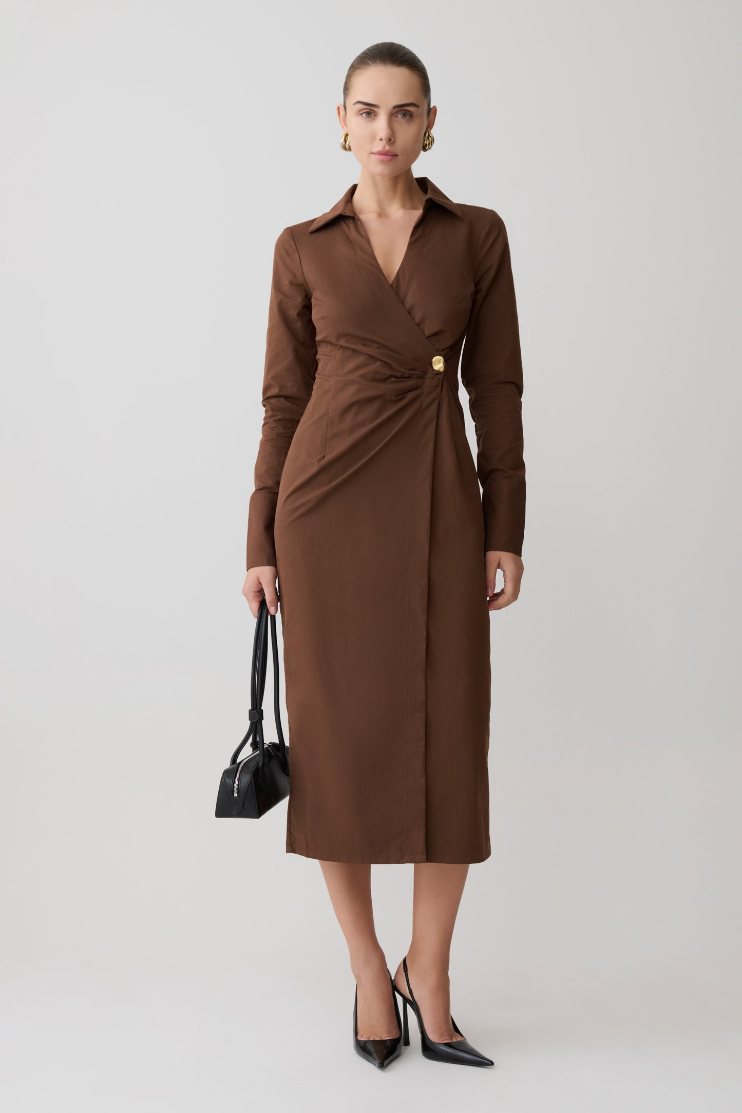 Woman wearing a brown dress with a plain background
