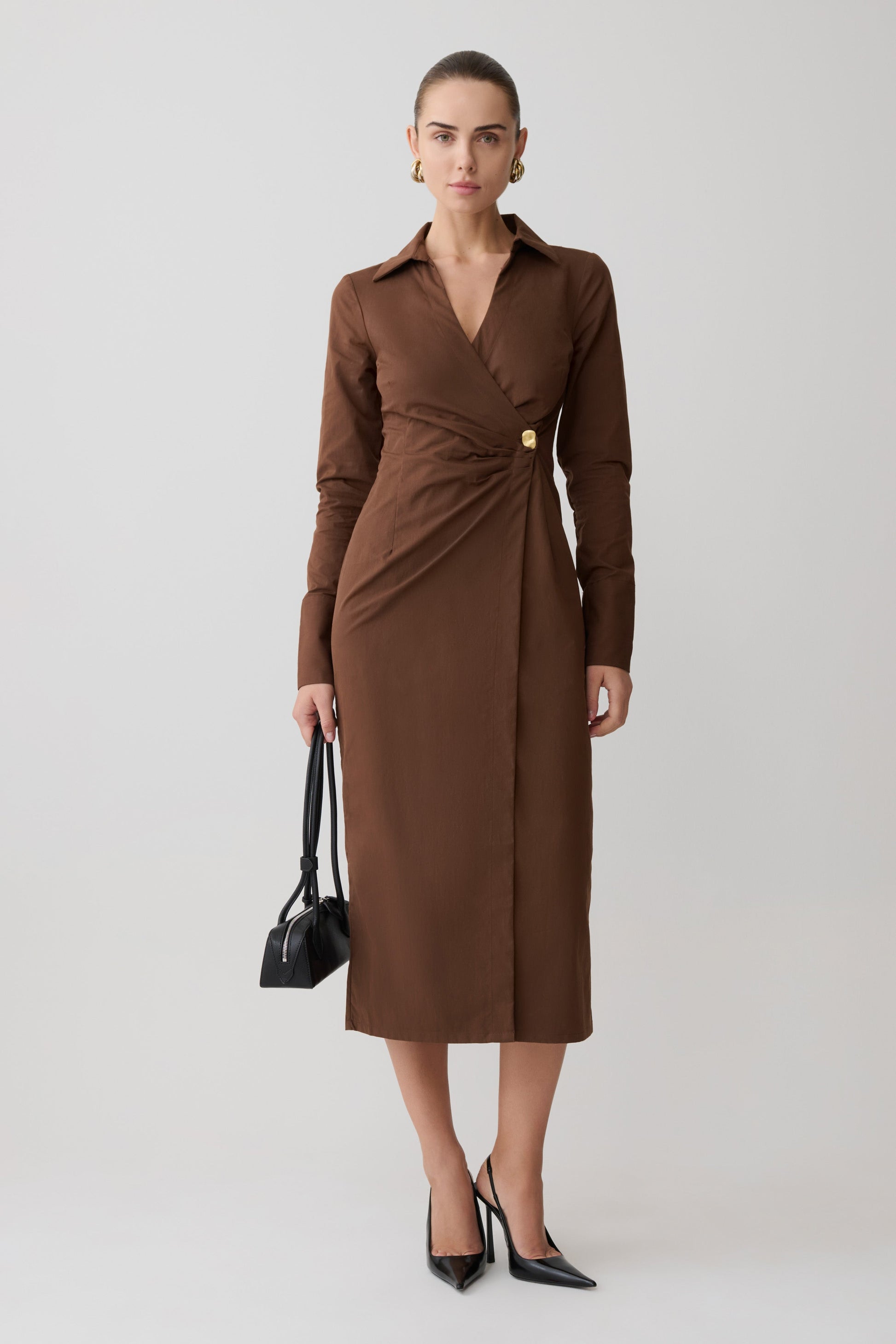 Woman wearing a brown dress with a plain background