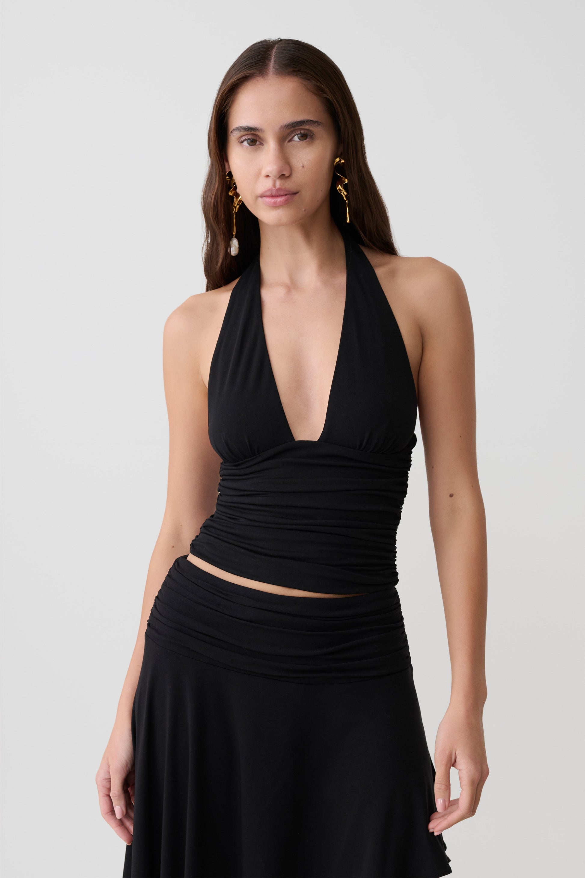 Woman wearing a black modal gathered halter top. 