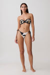Woman wearing a black and white floral patterned bikini set.