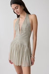 Woman wearing a silver halter pleated mini dress.